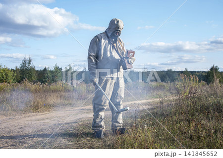 An ecologist in protective gear monitors the environment. 141845652