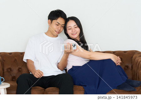 スマートフォンを操作する若い男女 スマートフォンを操作する若い男女 141845973