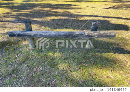 A wooden car barrier located along the perimeter of a public park A wooden car barrier located along the perimeter of a public park 141846455