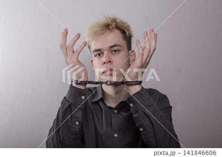 a handcuffed prisoner showing emotion. a handcuffed prisoner showing emotion. 141846606