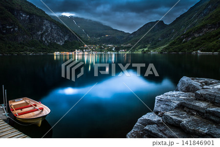 Fjord Lake at Blue Hour with Rowboat and Mountain Village 141846901