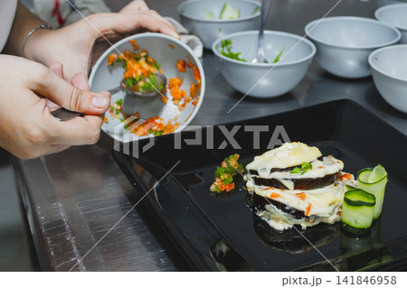 Chef plating healthy gastronomy dish, creating an innovative culinary experience with fresh vegetables for a sustainable and creative global cuisine celebration. Vegan food 141846958