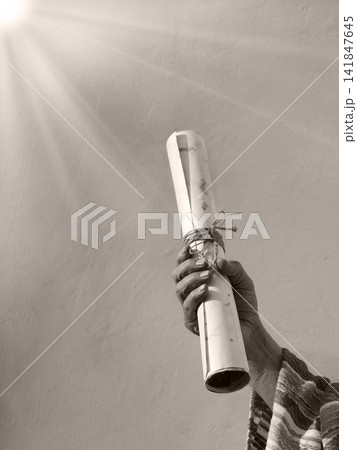 Male hand holding an old scroll Male hand holding an old scroll 141847645