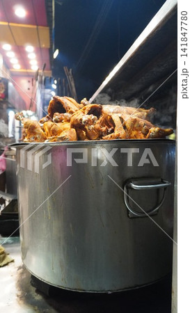Large steel pot with cooked food on a stove at a street food stall, traditional cooking method and kitchen concept Large steel pot with cooked food on a stove at a street food stall, traditional cooking method and kitchen concept 141847780