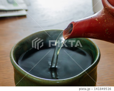 湯のみ茶碗に急須でお茶を注ぐ 湯のみ茶碗に急須でお茶を注ぐ 141849516
