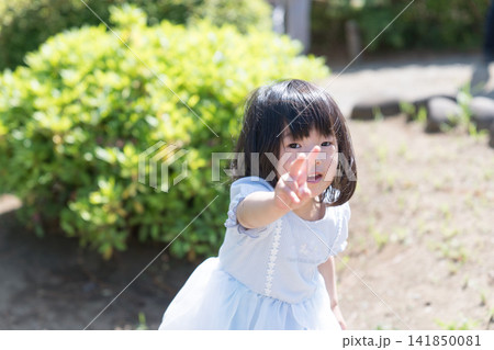 公園でカメラに向かって手を伸ばしピースサインをする日本人の女の子の幼児 公園でカメラに向かって手を伸ばしピースサインをする日本人の女の子の幼児 141850081