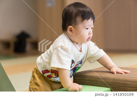 キッズルームでおもちゃを持ち遊ぶ日本人の男の赤ちゃん キッズルームでおもちゃを持ち遊ぶ日本人の男の赤ちゃん 141850109