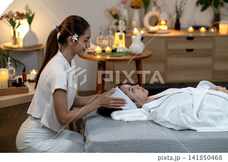 Asian adult women receive professional spa facial treatment for relaxation beauty wellness soothing skin therapy tranquil environment Asian adult women receive professional spa facial treatment for relaxation beauty wellness soothing skin therapy tranquil environment 141850468