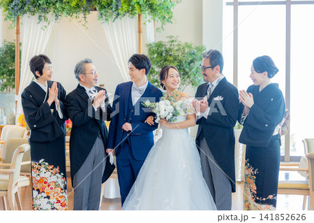 披露宴会場で並ぶ新郎新婦と両親の家族写真 披露宴会場で並ぶ新郎新婦と両親の家族写真 141852626