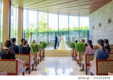 結婚式の祭壇に立つ新郎新婦のウェディングシーン 141852649