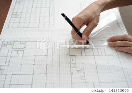 定規とペンを使って建築図面に線を引く建築士の手元 定規とペンを使って建築図面に線を引く建築士の手元 141853096