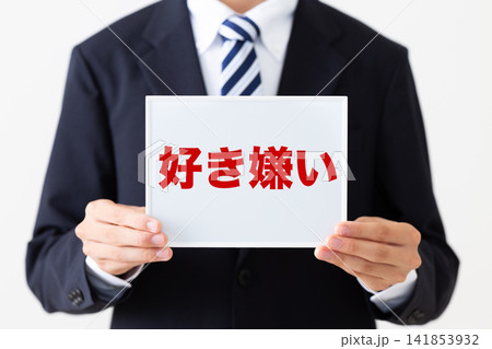 好き嫌いのホワイトボードを持つリクルートスーツを着た若い男性ビジネスマン 好き嫌いのホワイトボードを持つリクルートスーツを着た若い男性ビジネスマン 141853932