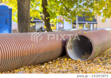 Pipes lay on ground covered with yellow leaves in autumn season 141853973