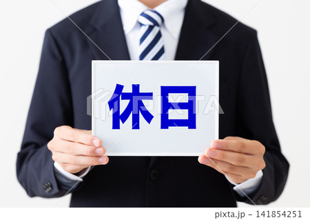 休日のホワイトボードを持つリクルートスーツを着た若い男性ビジネスマン 休日のホワイトボードを持つリクルートスーツを着た若い男性ビジネスマン 141854251