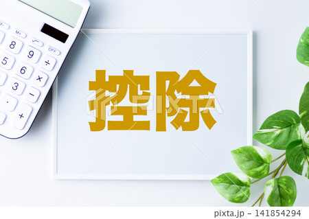 控除の文字のホワイトボードと白い電卓 控除の文字のホワイトボードと白い電卓 141854294