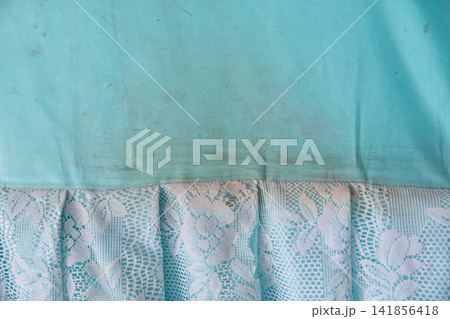 dirty light blue fabric with white lace fringe showing dark grime stains. Concept of laundry stain removal and delicate fabric care. dirty light blue fabric with white lace fringe showing dark grime stains. Concept of laundry stain removal and delicate fabric care. 141856418
