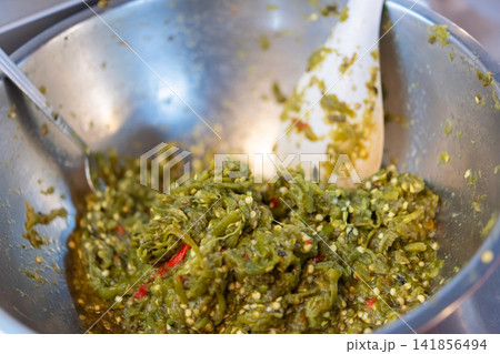 Traditional Thai roasted green chili dip prepared crushed peppers spices metal bowl representing spicy local cuisine condiment authentic street food Traditional Thai roasted green chili dip prepared crushed peppers spices metal bowl representing spicy local cuisine condiment authentic street food 141856494