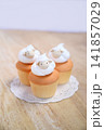 木のテーブルの上のひつじクリームカップケーキ 141857029
