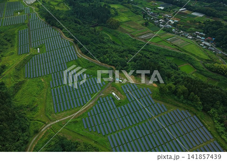 群馬県高崎市の丘陵斜面に広がる太陽光パネルと農村風景の空撮写真 群馬県高崎市の丘陵斜面に広がる太陽光パネルと農村風景の空撮写真 141857439