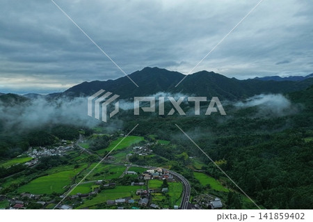 三重県御浜町の山間部に広がる霧と集落を捉えた空撮写真 141859402