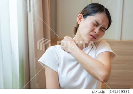 Asian woman having shoulder and neck pain from working longtime. Shoulder pain is when rotator cuff tendons become inflamed or trapped in your shoulder. Asian woman having shoulder and neck pain from working longtime. Shoulder pain is when rotator cuff tendons become inflamed or trapped in your shoulder. 141859581