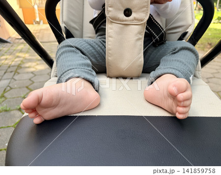 A baby's bare feet and legs in a stroller outdoors A baby's bare feet and legs in a stroller outdoors 141859758
