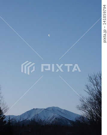 夜明け前の澄んだ青空に輝く月と雪残る雄大な山並み 夜明け前の澄んだ青空に輝く月と雪残る雄大な山並み 141859794