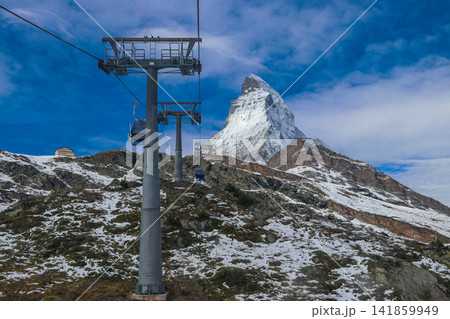 Overhead cable car to the top of Klein Matterhorn mountain with the iconic Matterhorn mountain peak in the background, Zermatt, Switzerland 141859949