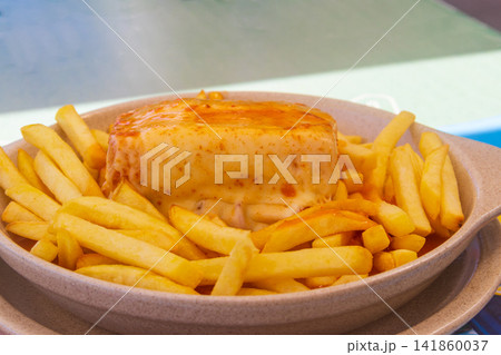 Francesinha sandwich with french fries on a plate. Typical food from Porto, Portugal Francesinha sandwich with french fries on a plate. Typical food from Porto, Portugal 141860037