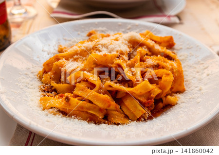 Tagliatelle pasta with bolognese sauce and grated cheese on a table Tagliatelle pasta with bolognese sauce and grated cheese on a table 141860042
