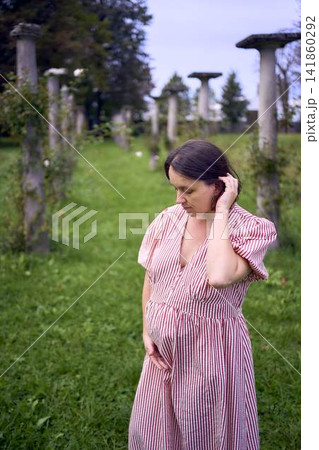 Pregnant mature woman posing by ancient stone columns 141860292