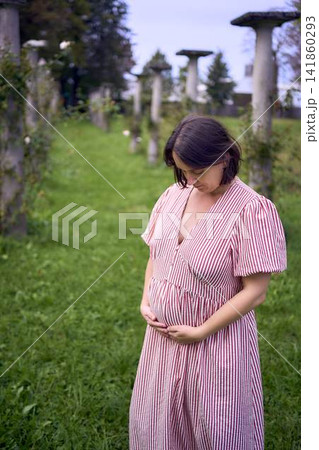 Pregnant mature woman posing by ancient stone columns Pregnant mature woman posing by ancient stone columns 141860293