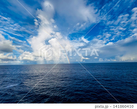 雲間から差し込む光と大海原にかかる虹 雲間から差し込む光と大海原にかかる虹 141860410