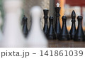 Black Chess Pieces on Outdoor Board with Blurred Foreground 141861039