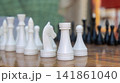 White Chess Pieces Standing on Outdoor Wooden Board Close Up 141861040