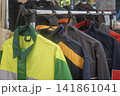 Protective Workwear and Jackets Hanging Outdoors on Clothes Rack 141861041