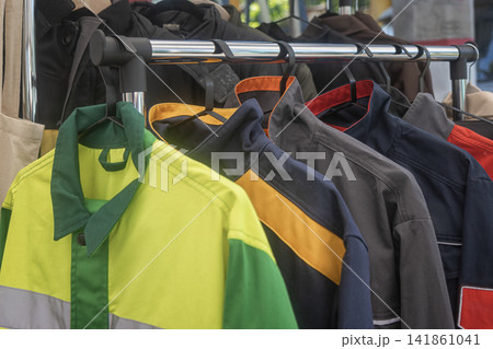 Protective Workwear and Jackets Hanging Outdoors on Clothes Rack Protective Workwear and Jackets Hanging Outdoors on Clothes Rack 141861041