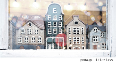 Small houses figurines in a window Small houses figurines in a window 141861359