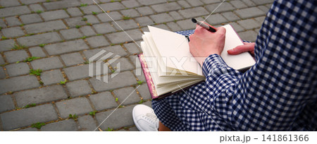 Girl holds a book to write Girl holds a book to write 141861366