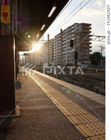 早朝の朝日に照らされる駅ホームと線路、ローカル鉄道風景　縦構図｜旅行・観光PRやSNS向けの縦型素材 141862607