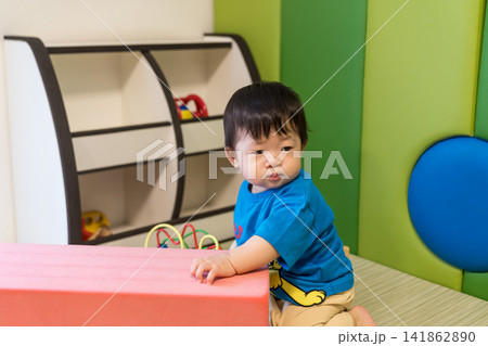 キッズルームのピンクのソフトブロックにもたれている日本人の男の赤ちゃん キッズルームのピンクのソフトブロックにもたれている日本人の男の赤ちゃん 141862890
