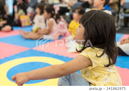 室内遊び場のショーを見つめる日本人の女の子の幼児 室内遊び場のショーを見つめる日本人の女の子の幼児 141862975