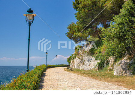 Coastal stone walking path with vintage lampposts in Rovinj, Croatia. Coastal stone walking path with vintage lampposts in Rovinj, Croatia. 141862984