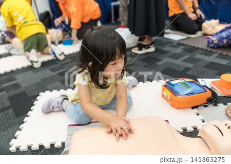救急救命体験イベントでAEDに触れる日本人の女の子の幼児 救急救命体験イベントでAEDに触れる日本人の女の子の幼児 141863275