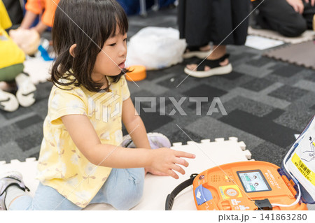 救急救命体験イベントでAEDに触れる日本人の女の子の幼児 救急救命体験イベントでAEDに触れる日本人の女の子の幼児 141863280