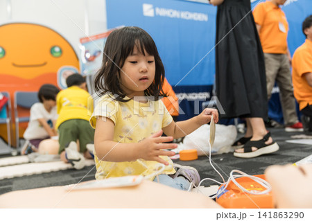 救急救命体験イベントでAEDに触れる日本人の女の子の幼児 救急救命体験イベントでAEDに触れる日本人の女の子の幼児 141863290