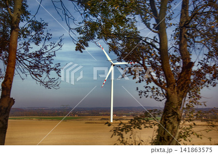 Wind machines among fields against bright sky 141863575