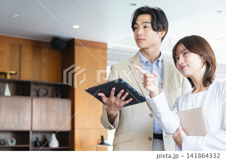 タブレットを片手に未来や目標を指差す男女のビジネスパーソン タブレットを片手に未来や目標を指差す男女のビジネスパーソン 141864332