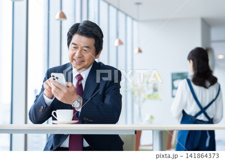 カフェでくつろぐミドルのビジネスマン　撮影協力：学校法人電波学園　東京電子専門学校 141864373