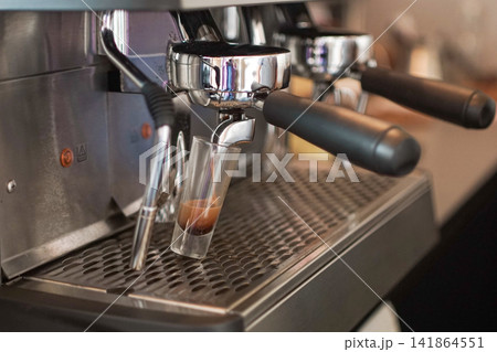 Espresso Extraction From Portafilter on Professional Coffee Machine in Modern Cafe Environment Espresso Extraction From Portafilter on Professional Coffee Machine in Modern Cafe Environment 141864551